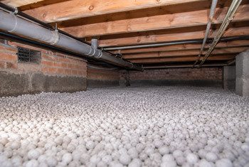Kruipruimte isoleren met isolatiechips als bodemisolatie Afgewerkte kruipruimte met een gelijkmatige laag isolatiechips op de bodem voor bodemisolatie